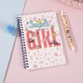 Vista detallada de cuaderno de espiral rosa con pompón y bolígrafo de gel de dibujos - Rosa Super Girl