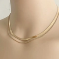 Detail of layered gold snake bone chain and bead necklace on a mannequin - Blade Chain Gold