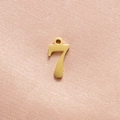 Close-up of a polished gold number 7 pendant with an integrated hanging loop for DIY jewelry - Gold Number 7