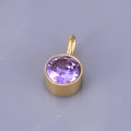 Detailed macro view of a gold-plated birthstone pendant with a round purple gemstone - Round Pendant / Violet