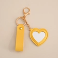 Yellow heart leather keychain with built-in mirror and gold metal clip on beige base - Heart Mirror / Yellow