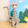 Plush cat toy with grey and black stripes sitting on a wooden table, cute animal doll - Grey Cat / 25cm