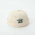 Close-up of beige Miki Hat with green Est. Number 23 embroidery on canvas texture - Letter 23 Style / Beige