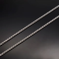 Close-up of polished stainless steel wheat chain showing intricate woven texture and silver shine - Stainless Steel / Steel Color Necklace Chain