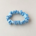 Elastic light blue satin scrunchie for women with premium silk texture on white surface - Sky Blue