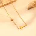 Détail d'un collier croix en acier doré avec gemme sertie sur fond de cuir élégant - Collier Or