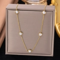 Collier en acier titane doré avec cinq perles blanches présenté sur un coffret à bijoux - Collier (XLH1265) / Or