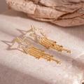 Detailopname van gouden ster-oorbellen met zirkonen op een stenen oppervlak - Gouden Ster Kwastje Stijl (S925 Sterling Zilveren Naald)