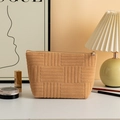Detail van de camel corduroy make-uptas met geometrische textuur en metalen rits - Abrikoos
