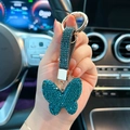 Funkelnder dunkelblauer Strass-Schmetterling-Schlüsselanhänger mit Lederband im Auto - Blaugrün