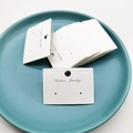 White cardboard earring display card with hanging hook and Fashion Jewelry text - White