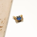 Close-up of golden crab pendant featuring a central blue gemstone on reflective surface - 6# Crab Blue Zircon