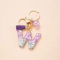 Detail of glitter purple resin letter W keychain with matching tassel and gold hardware - Letter W