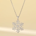 Élégant collier flocon de neige argenté avec cristaux clairs sur fond beige chaud - Ensemble Pendentif Flocon / Or (Chaîne O Titane Flocon Doré)