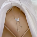Detailed close-up of a titanium steel necklace with butterfly pendants and shell finish - Titanium Steel / Silver