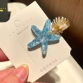 Detail of starfish hair clip with blue sequins, pearls and a golden shell element - 6* Beach Starfish - Blue