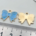 Light blue enamel bow charm with gold plating and sunburst texture on reverse side - Lake Blue Bow