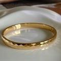 Macro view of 18k gold plated stainless steel bangle with faceted geometric texture - 6mm Width / Gold