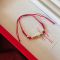 Close-up of red braided rope bracelet with glass beads and enamel peace and happiness charms - Peace and Happiness Tag Style (HB5012-10)