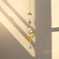 Detail view of brass butterfly suncatcher reflecting rainbow light spots on beige wall - Wide Wing Butterfly