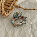 Macro detail of tortoiseshell resin hair claw showing vintage marble pattern and texture - Light Blue Oil Painting