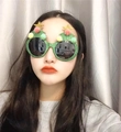 Detail view of green Christmas tree glasses with pom-poms and gold star on a model - Green Glitter Christmas Tree