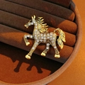 Macro detail of a vintage horse brooch with white rhinestones on a gold metal base - Gold Pave Set Horse