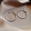 Minimalist silver hoop earrings displayed on champagne satin fabric background - Oversized Hoop (29#)