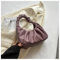 Elegante borsa a tracolla viola plissettata in morbida ecopelle su un blazer beige - Viola