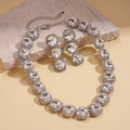 Detailed macro view of silver geometric necklace and drop earrings with round crystals - Necklace-Silver (Two-Piece Set)