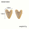 Detail shot of gold heart earrings with rhinestones measuring 1.6cm by 1.8cm - White