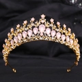 Detail of golden alloy crown with pink teardrop gemstones and white crystals on black fabric - H1130 KC Gold + Pink Opal