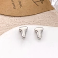 Minimalist silver T-shaped stud earrings in polished metal finish on a ceramic tray - Silver Letter T