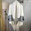 Macro shot of tricolor striped knit shawl featuring a thick faux fur collar and fringe trim - Mixed White