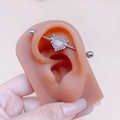 Silver industrial barbell with pink opal heart pendant shown on a silicone ear model - Heart Pendant Industrial Barbell