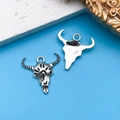 Vintage silver cow skull charms for DIY jewelry making displayed on a blue background - Skull Bull Head 20x20mm