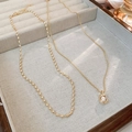 Detail of gold-plated pearl pendant and beaded chain necklace in a jewelry box - Gold Bean Pearl Style