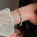 Detalle de brazalete chapado en oro de 18K con circonitas de colores en la muñeca - Brazalete Abierto de Circonita de Colores (Plateado) / Plateado