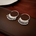 Macro λήψη από ασημένια σκουλαρίκια C με κρεμαστά μεταλλικά στοιχεία σε δερμάτινη επιφάνεια - Ασημένιο Άγκιστρο Αυτιού με Φούντα Σταγόνα