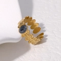 Makro-Detail eines verstellbaren Goldblatt-Rings mit dunklem ovalem Edelstein - Perlmutt-Schwarz