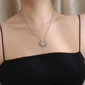 Elegante collar con colgante de sol en acero de titanio plateado sobre una modelo - Plata 40+5CM
