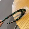 Dettaglio della forcina in acetato a forma di U con motivo tartarugato e punti dorati - Tartarugato Verde
