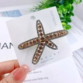 Starfish hair clip with sparkling brown crystals on a white display card - Starfish Champagne