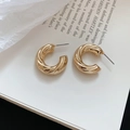 Close-up of golden C-shaped twisted metal hoop earrings resting on an artistic book page - 925 Silver Needle / Gold Twisted Texture Style (17#)