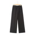 Detail of black wide-leg joggers featuring a drawstring elastic waist and central seam line - Black Pants