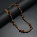 Bohemian surf necklace with brown coconut beads and irregular turquoise stones on a dark stand - Tiger Eye Color