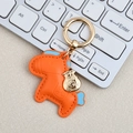 Orange leather horse keychain with light blue accents and a gold lucky bag charm - Mini / Orange