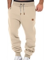 Detail of khaki men's joggers with drawstring waistband and brown square leather patch - Khaki