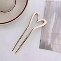 Dettaglio di una forcina dorata minimalista a forma di U con un design a cuore - oro lucido