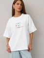 Oversized λευκό βαμβακερό μπλουζάκι με πολύχρωμο ρωσικό κείμενο και στρογγυλή λαιμόκοψη - S / Λευκό